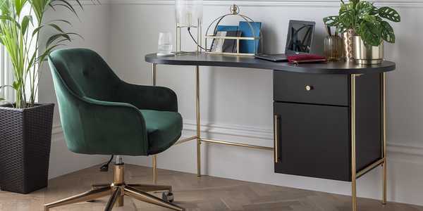A compact home office set up with a storage desk and a velvet office chair. 